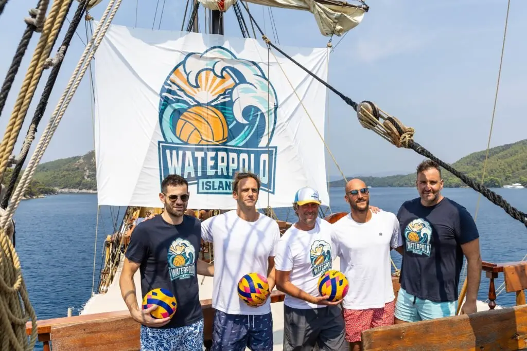 Nikša Dobud with campers in front of the Waterpolo Island flag